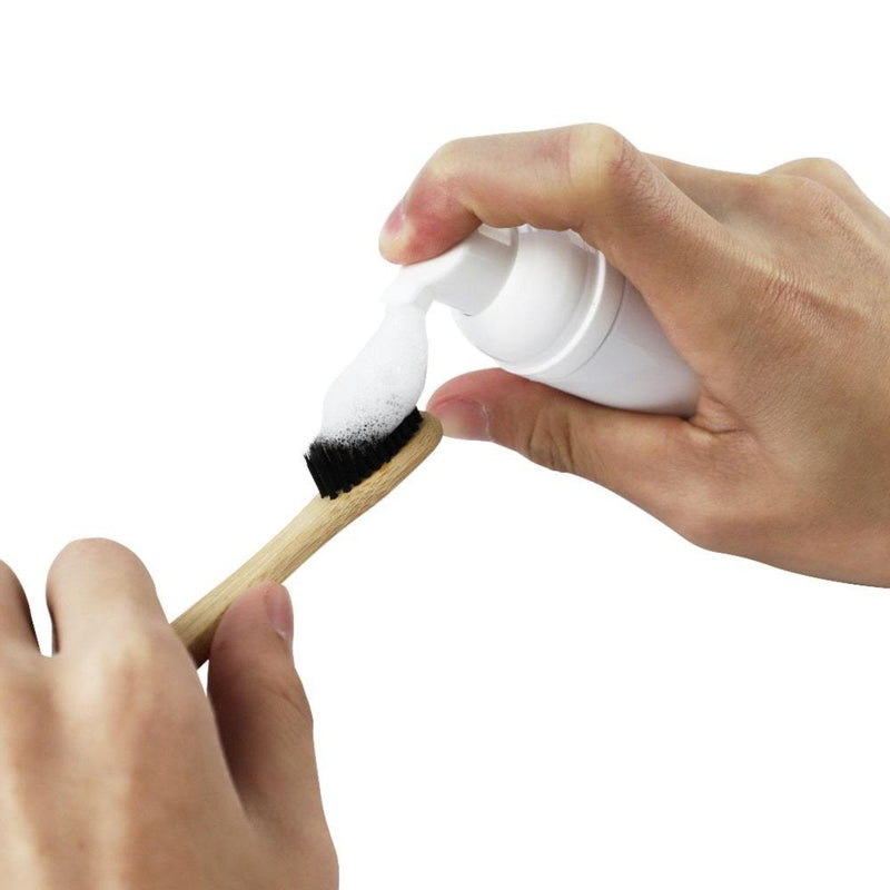 Zahnbürste mit Diamond Smile Zahnbleaching Schaum vor weißen Hintergrund